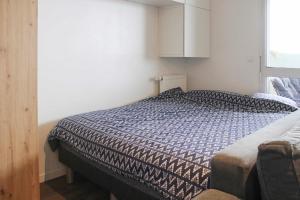 een slaapkamer met een bed met een zwart-wit dekbed bij Brand new studio with an open view on Paris in Arcueil
