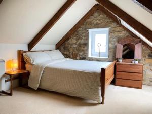 a bedroom with a bed and a stone wall at The Post House in Charlestown