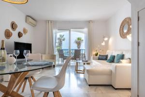 een woonkamer met een tafel en een bank bij Sea Front Beach House Micaela I in Marbella