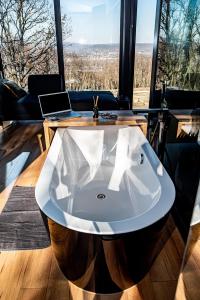 a bath tub in a room with a laptop on a table at ForRest Boutique Cabin in Dunabogdány