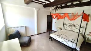 ein Schlafzimmer mit einem Metallbett und einem Stuhl in der Unterkunft Poggio alla Pietra 26 in Porrona