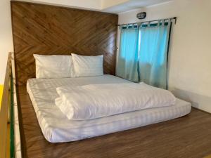 een groot wit bed met een houten hoofdeinde in een kamer bij B475house in Nha Trang