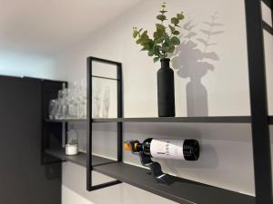 a black shelf with a bottle of wine and a vase at Apartment in Birkdale - 2 bedrooms in Southport