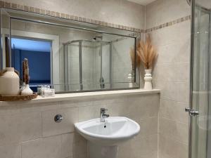 a bathroom with a sink and a mirror at Apartment in Birkdale - 2 bedrooms in Southport
