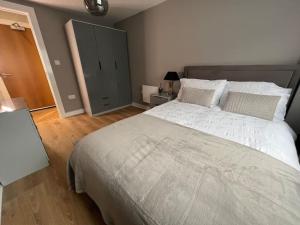 a bedroom with a large bed and a dresser at Apartment in Birkdale - 2 bedrooms in Southport