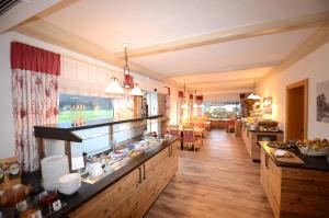 uma grande cozinha com pisos em madeira e uma sala de jantar em Hotel Cafe Fuggerhof em Oberstdorf