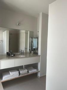 ein Badezimmer mit einem Waschbecken, einem Spiegel und Handtüchern in der Unterkunft שדות וים in Schawe Zion