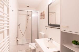 a white bathroom with a sink and a shower at Pier 1 in Heringsdorf