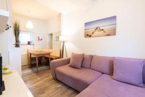 a living room with a purple couch and a table at Pier 1 in Heringsdorf