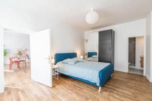 Un dormitorio con una cama azul y una mesa en L'Orée Proche centre ville en Saint-Germain-en-Laye