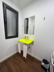 a bathroom with a yellow sink and a mirror at Pérola do Ar - Estúdio no coração de Setúbal in Setúbal +16 photos