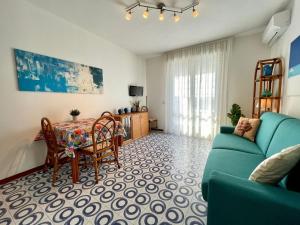 a living room with a blue couch and a table at Comfy studio with shared pool in Porto Santa Margherita di Caorle +12 photos