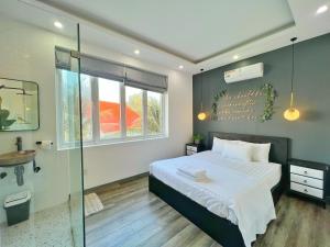 Un dormitorio con una cama y una ducha de cristal. en The Beachhouse Villa- Biệt Thự 4 Phòng Bãi Sau- 4 bedrooms Villa- 5' to Bai Sau Beach, en Xã Thang Tam