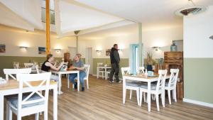 un groupe de personnes assises à table dans un restaurant dans l'établissement F-1010 Strandhaus Mönchgut Bed&Breakfast DZ 37 strandnah, inkl Frühstück, à Lobbe