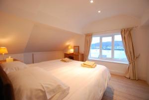 um quarto com 2 camas e uma grande janela em Estuary View Apartment em Deganwy