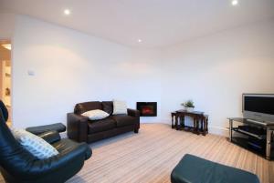 a living room with a couch and a tv at Estuary View Apartment in Deganwy