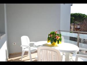 a white table and chairs with a plant on a balcony at Modern and bright apartment - Beahost Rentals in Rosolina Mare +17 photos