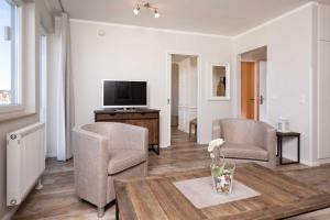a living room with a table and two chairs and a tv at Residenz Bel Vital Wohnung 41 in Binz