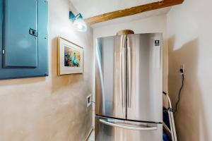 frigorifero in acciaio inossidabile in cucina con mobili blu di Hacienda del Cañón a Taos