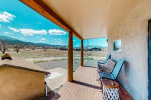 een veranda met stoelen en uitzicht op de woestijn bij Hacienda del Cañón in Taos