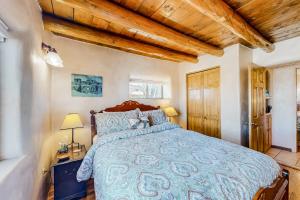 een slaapkamer met een bed en een houten plafond bij Hacienda del Cañón in Taos