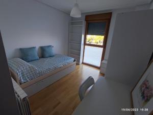 um pequeno quarto com uma cama e uma janela em Apartamento La Bien Cercada em Zamora