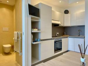 a kitchen with white cabinets and a tv on the wall at Ad appena 50 metri dal mare! in Trapani