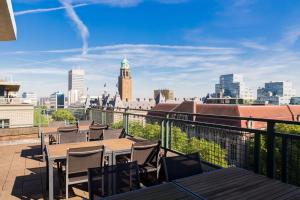 a balcony with tables and chairs and a view of the city at NH Atlanta Rotterdam Hotel in Rotterdam