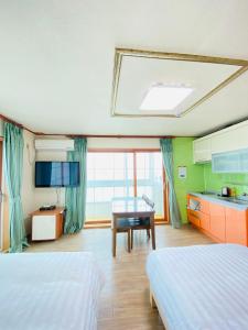 Habitación de hotel con 2 camas y mesa en Billions Motel, en Gangneung