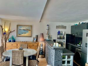 uma cozinha com uma mesa e uma bancada em Appartement Vue Mer - RDC - Parking Privé - Meublé Tourisme 4 étoiles em Cap d'Agde