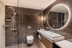 a bathroom with a toilet and a sink and a mirror at NH Collection Copenhagen in Copenhagen