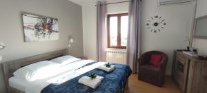 1 dormitorio con 1 cama, 1 silla y 1 reloj en Sobe Bukaleta Loznati, en Loznati