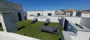 d'un balcon avec des chaises et de l'herbe sur le toit. dans l'établissement Bendito Viento, à Tarifa