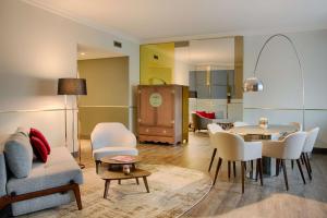 a living room with a couch and a table and chairs at NH Collection Porta Nuova in Milan