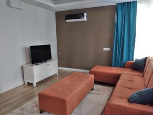a living room with a couch and a tv at Şehir merkezinde iki odalı daire in Antalya