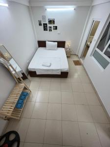 a small bedroom with a bed and a tiled floor at Bluebell Hotel in Hanoi