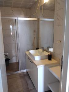een witte badkamer met een wastafel en een douche bij Şehir merkezinde iki odalı daire in Antalya