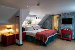 1 dormitorio con 1 cama grande y TV en The Double Red Duke, Cotswolds, en Clanfield