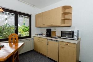 a kitchen with a microwave and a table and a window at 2-Personenappartement-in-Schaprode-auf-Ruegen-Zi1 in Schaprode