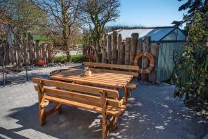 a wooden bench sitting next to a wooden fence at 2-Personenappartement-in-Schaprode-auf-Ruegen-Zi1 in Schaprode +6 photos