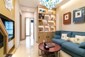 sala de estar con sofá azul y mesa en Cloud Land Apartment 翡翠华庭 en Guangzhou