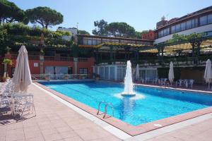 een zwembad met een fontein voor een gebouw bij V&V LLORET-APARTAMENTO EUROPA para 6PAX con jardín y piscina comunitaria,barbacoa,120m playa Canyelles in Lloret de Mar