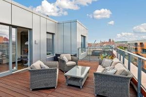 einen Balkon mit Stühlen und einem Tisch auf einem Gebäude in der Unterkunft Blue Mandarin Riverside in Danzig