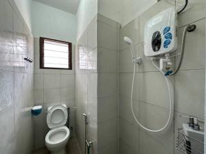 uma casa de banho com um chuveiro e um WC. em Ipoh Canning Garden Simple House 4R3B 12pax SY19 em Ipoh