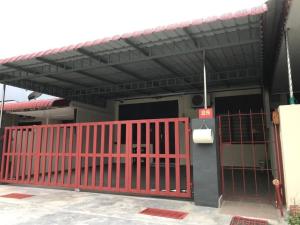 a red gate in front of a building at Ipoh Canning Garden Simple House 4R3B 12pax SY19 in Ipoh