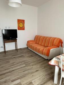 Il comprend un salon doté d'un canapé et d'une télévision à écran plat. dans l'établissement Podere 660 appartamento il Salice, à Marrucheto