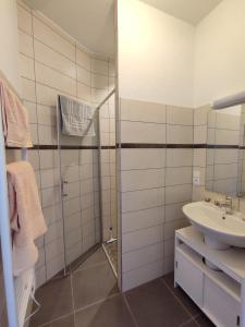 uma casa de banho branca com um lavatório e um chuveiro em Chambres d'Hôtes La Courlande em Saint-Haon-le-Vieux