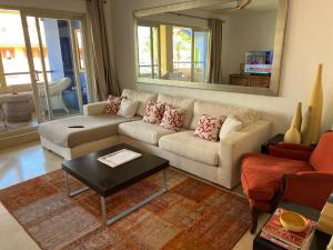 sala de estar con sofá blanco y espejo en Apartamento Puerto Sotogrande Marina, en Sotogrande