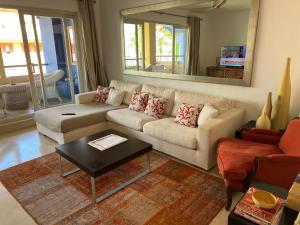 salon z białą kanapą i lustrem w obiekcie Apartamento Puerto Sotogrande Marina w mieście Sotogrande