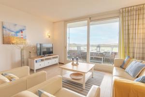 a living room with a couch and a tv at Duinerei Groote Keeten in Callantsoog